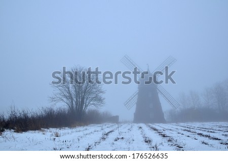 Spooky windmill a foggy day in a rural landscape