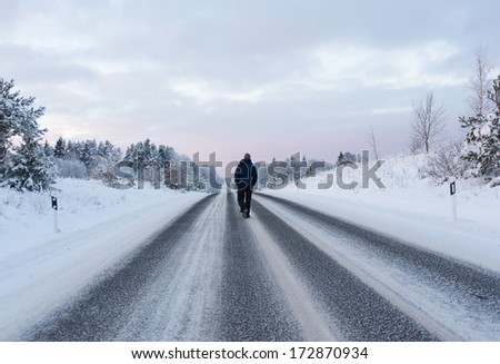Image of man walking away on winter road