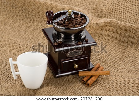 Image of Coffee mill with cup on fabric
