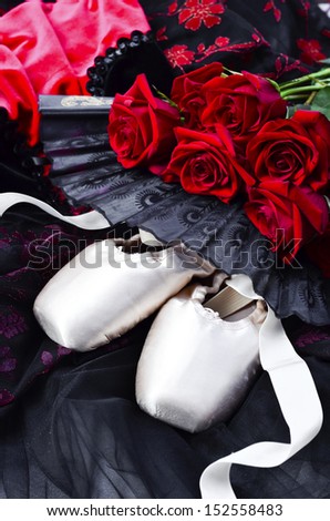 Composition of ballet shoes , dance costume and red roses