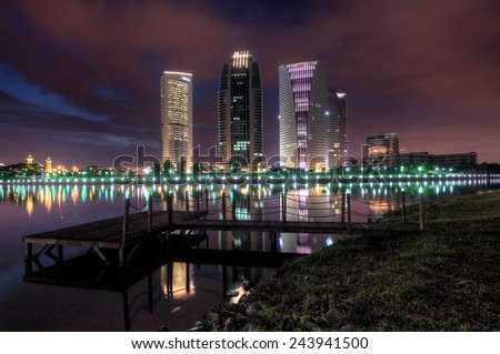 Night scene with modern building reflection at a Lake  Image has grain or noise and soft focus when view at full resolution. (Shallow DOF, slight motion blur )