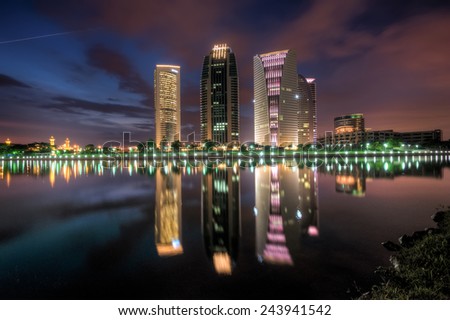 Night scene with modern building reflection at a Lake  Image has grain or noise and soft focus when view at full resolution. (Shallow DOF, slight motion blur )
