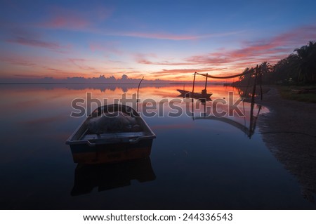 Fisherman boat on the beach during dawn hours (soft focus, shallow DOF, slight motion blur)