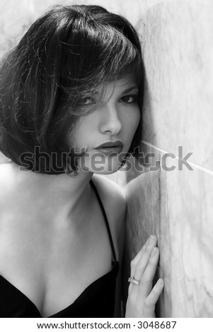 Young woman leaning her head against a wall