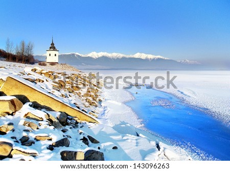 A rare view of frozen surface of Liptovska Mara lake in Winter. Tower and Rohace Mountains can be seen in the distance.