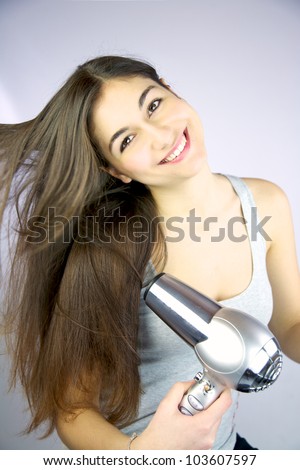 Female model smiling blowing air to her long silky hair
