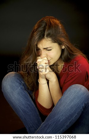 Scared young woman crying and praying