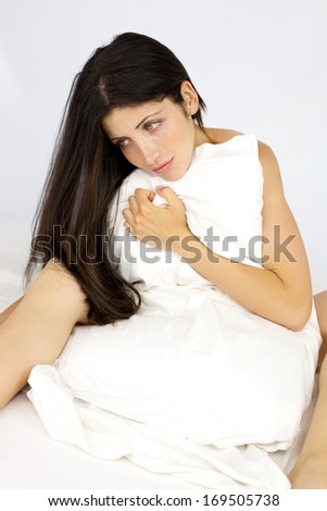 Gorgeous lady with long hair thinking sitting in bed