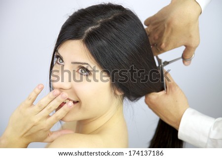 Happy woman getting long hair cut by hairdresser