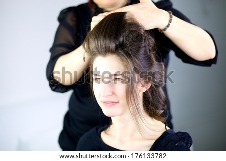 Beautiful female model getting hair done by professional hairstylist