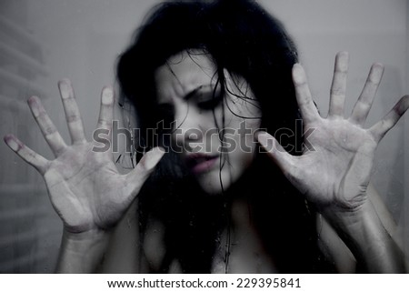 Scared woman trapped in glass wet