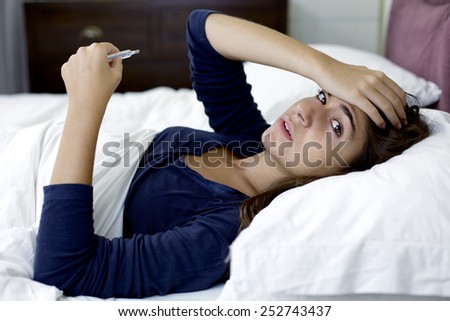 Unhappy sick woman in bed alone with fever