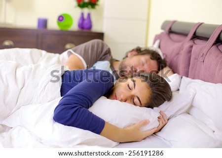 Cute married couple sleeping in bedroom
