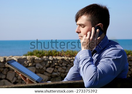 Cool man at work in front of blue ocean
