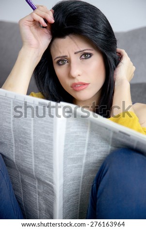 Woman unhappy looking for a job on newspaper
