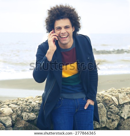Young hip man having a good time talking on the phone