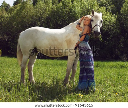 beautiful young woman with a horse in the forest