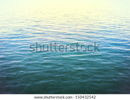 The calm surface of the Pacific ocean with cross-processed colors.  Image displays a distinct paper grain and texture at 100 percent.
