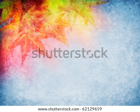 Soft focus fall leaves on a grunge paper background.