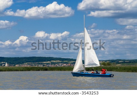 Three people on a sailing boat. Sailing lake Neusiedlersee, Austria.