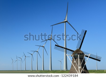 Traditional windmill 'De Goliath' and modern wind turbines in the Eemshaven, the Netherlands.