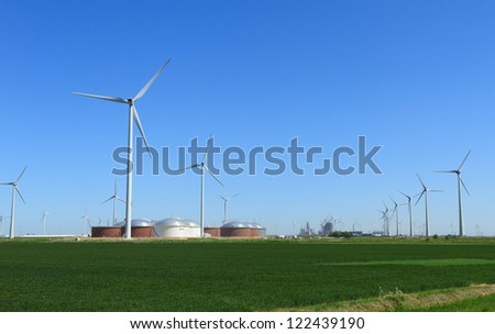 Modern wind turbines, fuel storage tanks and industry in the Eemshaven, Holland.