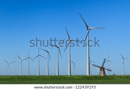 Traditional windmill \'De Goliath\' and modern wind turbines in the Eemshaven, the Netherlands.