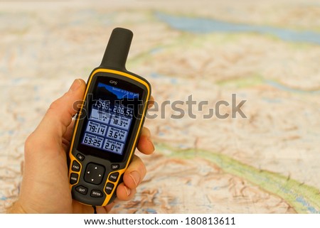 Hand held outdoor GPS and a hiking map.