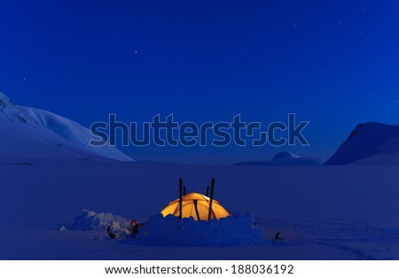 Tent during a cold night in the snow covered mountains of Lapland, Sweden.