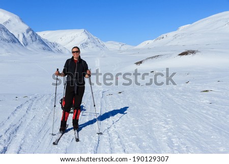 Happy female cross country skier (with pulka) on the Kungsleden trail in Sweden.