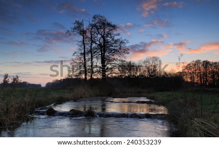 Small stream with fish pass during a colorful sunset.