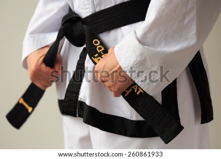 Taekwon-do woman with black belt getting ready for training.