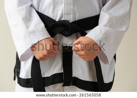 Taekwon-do woman with black belt, 1e dan, getting ready for training.