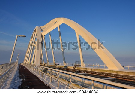 Snow on the cool curves of train and bike bridge in Groningen, Holland