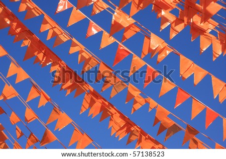 Orange flags, (also used on queens day in Holland) against a blue sky during the soccer world cup.