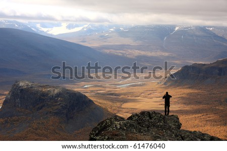 Hiker enjoying the view of autumn in Rapadalen valley, National Park Sarek, Sweden.