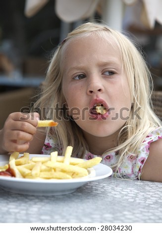Girl eats fried potatoes in fast food restaurants