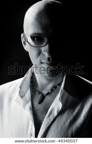 Bald man in a white shirt on a black background