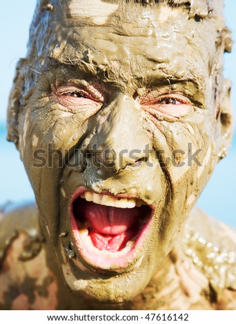 man\'s face is very dirty in the mud. Dirt is not curative