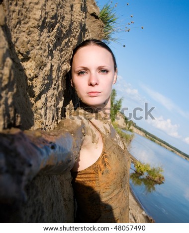 beautiful girl is leaning against the clay bank