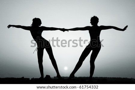 Silhouette of two young women against the evening sunset