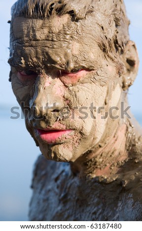Man's face is very dirty in the mud. Dirt is not curative