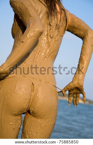Beautiful female back and buttocks in the mud