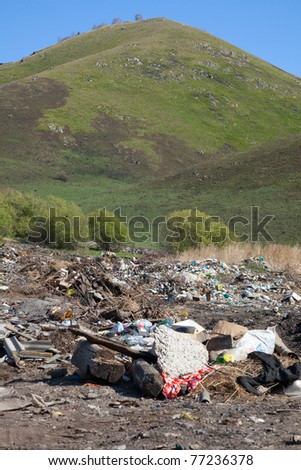 Piles of garbage on the background of the spring landscape