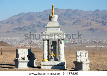Buddhist stupa in the mountains of Mongolia on the background of the settlement