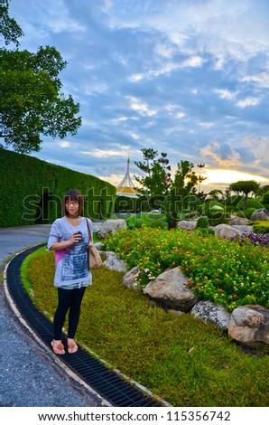 Cute Thai girl is wondering in the dreamy park, in the sunset