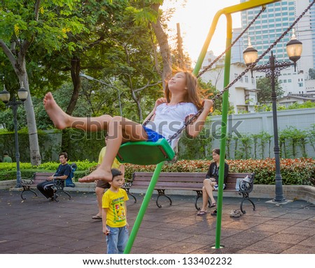 BANGKOK - MARCH 10: An unidentified child uses a swing on March 10, 2013 in Bangkok. Bangkok governor plans to build more public playgrounds for children to improve mental health, reduce violence and drugs problem in urban area of Bangkok.