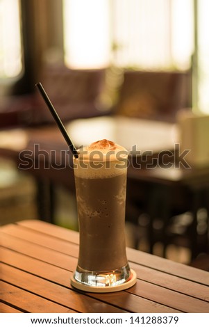 Cappuccino smoothie on the cafe\'s table in brown soothing atmophere