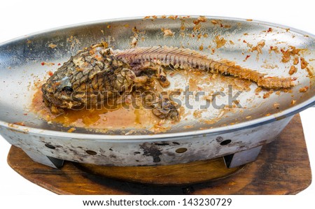 Fishbone of a snake-head fish in a metal bowl after everyone finish the meal