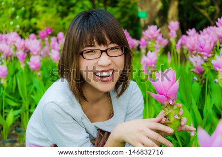 Cute Thai girl is very happy with flowers  Siam Tulip  in final retouch  She is laughing with joy which show a strong mental health.